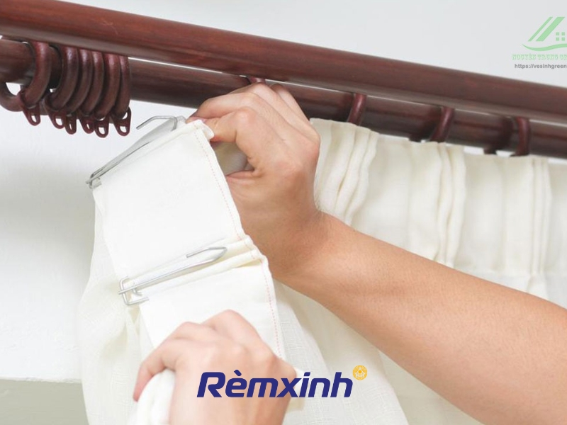 Tháo rèm cửa khỏi thanh treo và gỡ các móc để chuẩn bị giặt.