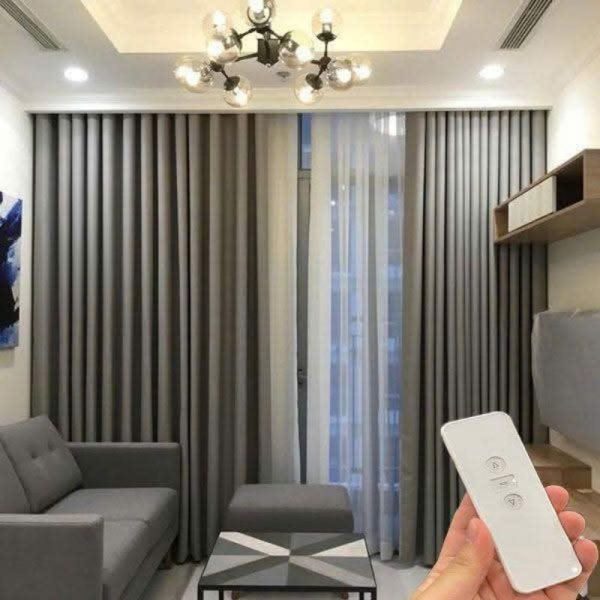Mẫu rèm vải tự động thông minh hai lớp màu ghi và voan trắng với điều khiển từ xa trong phòng khách hiện đại.